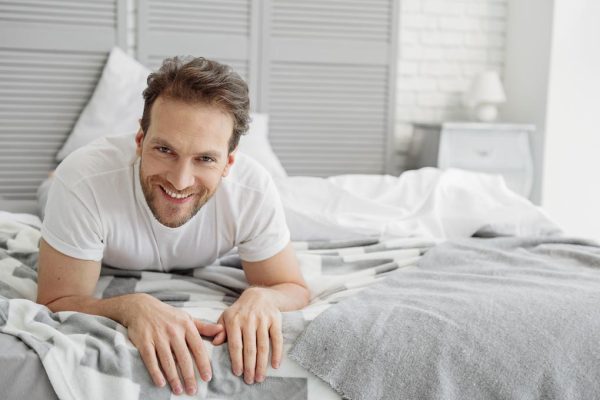 Carefree guy resting in bedroom