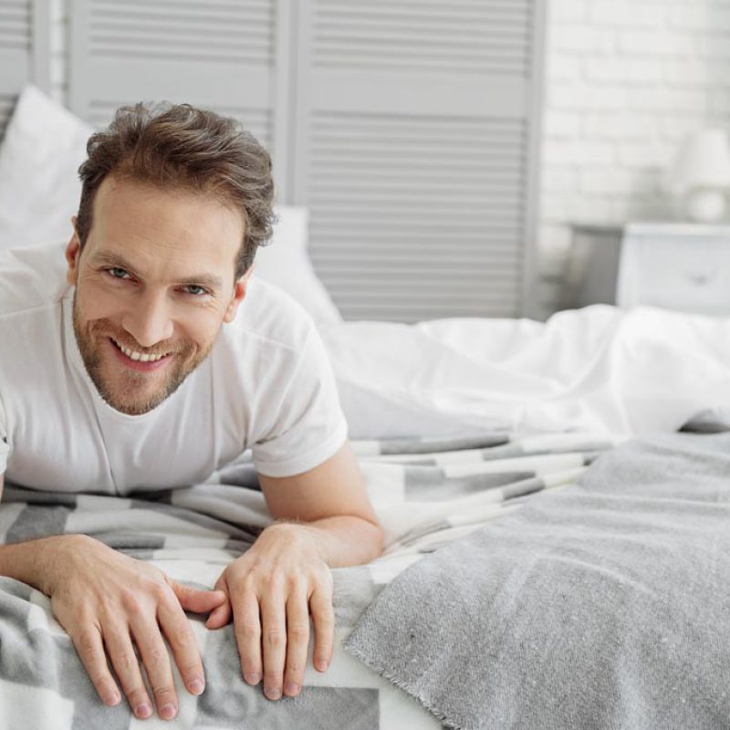 Carefree guy resting in bedroom